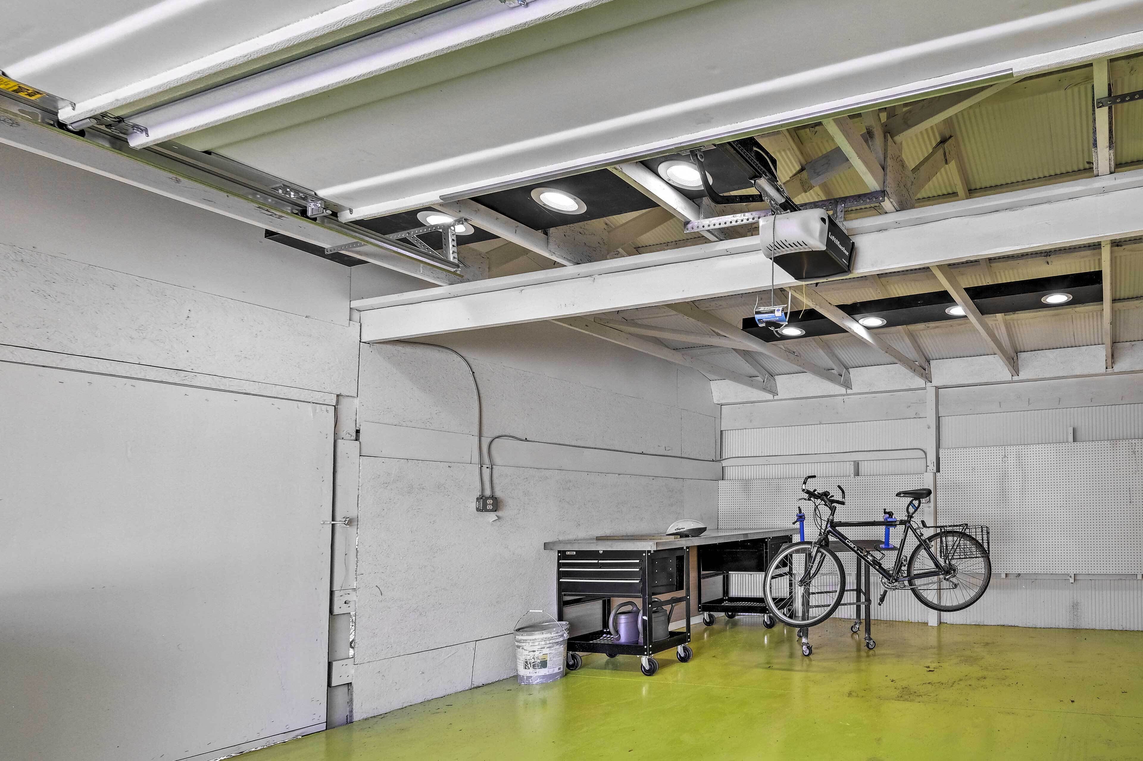 Un espacio interior amplio con piso verde, una bicicleta y un carrito con herramientas.