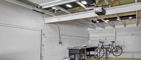 Un espacio interior amplio con piso verde, una bicicleta y un carrito con herramientas.
