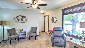 A living room with a ceiling fan, two armchairs, a coffee table, and a window with blinds. - Appleton Abode Near Lake Winnebago & Downtown (Appleton)