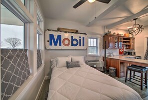 Une chambre avec un lit, une enseigne « Mobil », un coin cuisine et une vue sur l’extérieur.