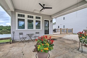 A covered patio with a ceiling fan, a table and chairs, and a large flower pot. - Lakefront Studio Guest Home on Hermann Wine Trail! (New Haven)