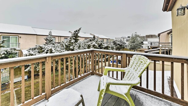 A balcony with a wooden railing, a green plastic chair, and a snow-covered lawn. - Family-friendly Wildwood Townhome ~ 3 Mi to Beach (Wildwood)