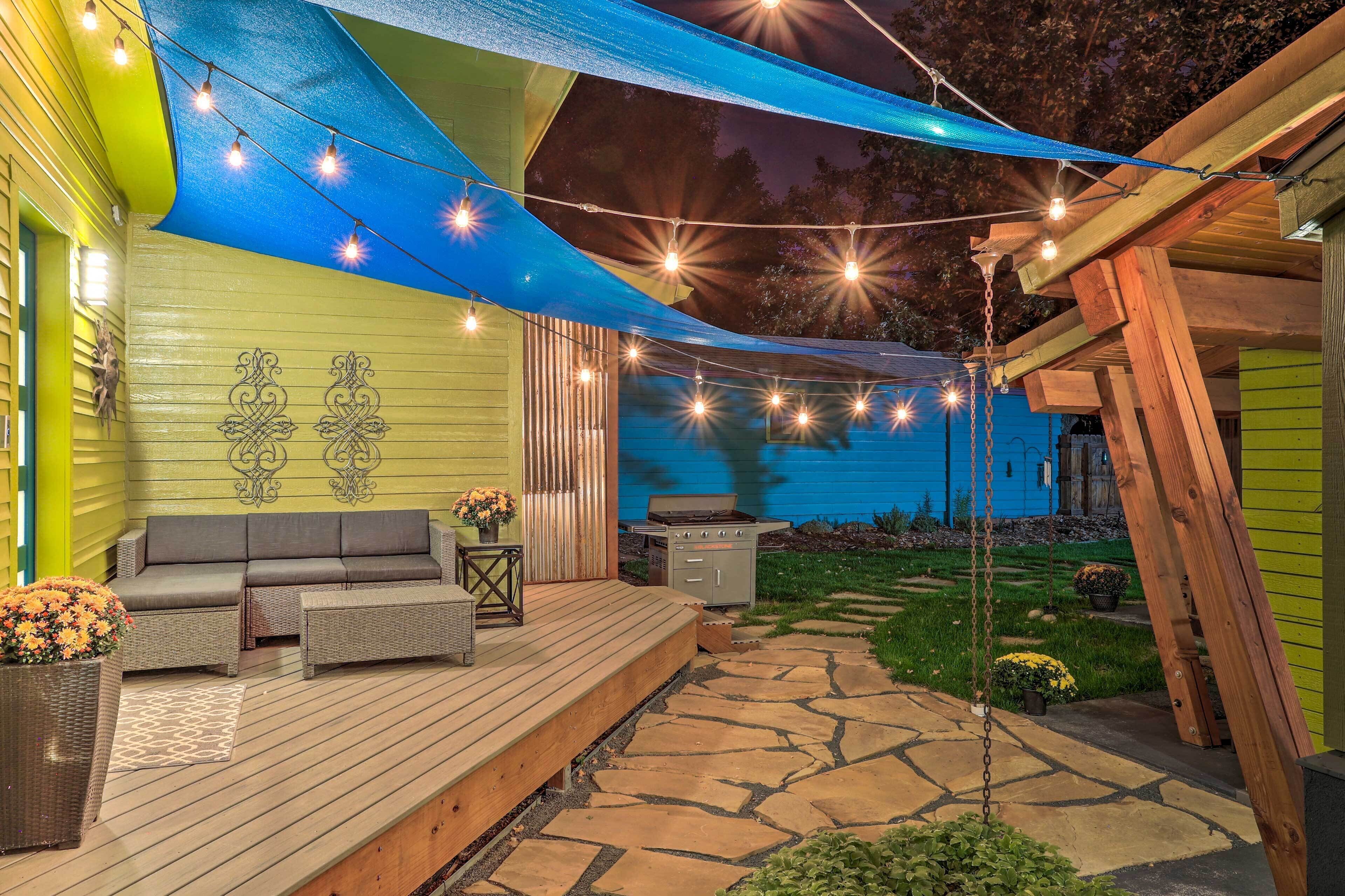 A patio with outdoor furniture, string lights, and a barbecue grill.