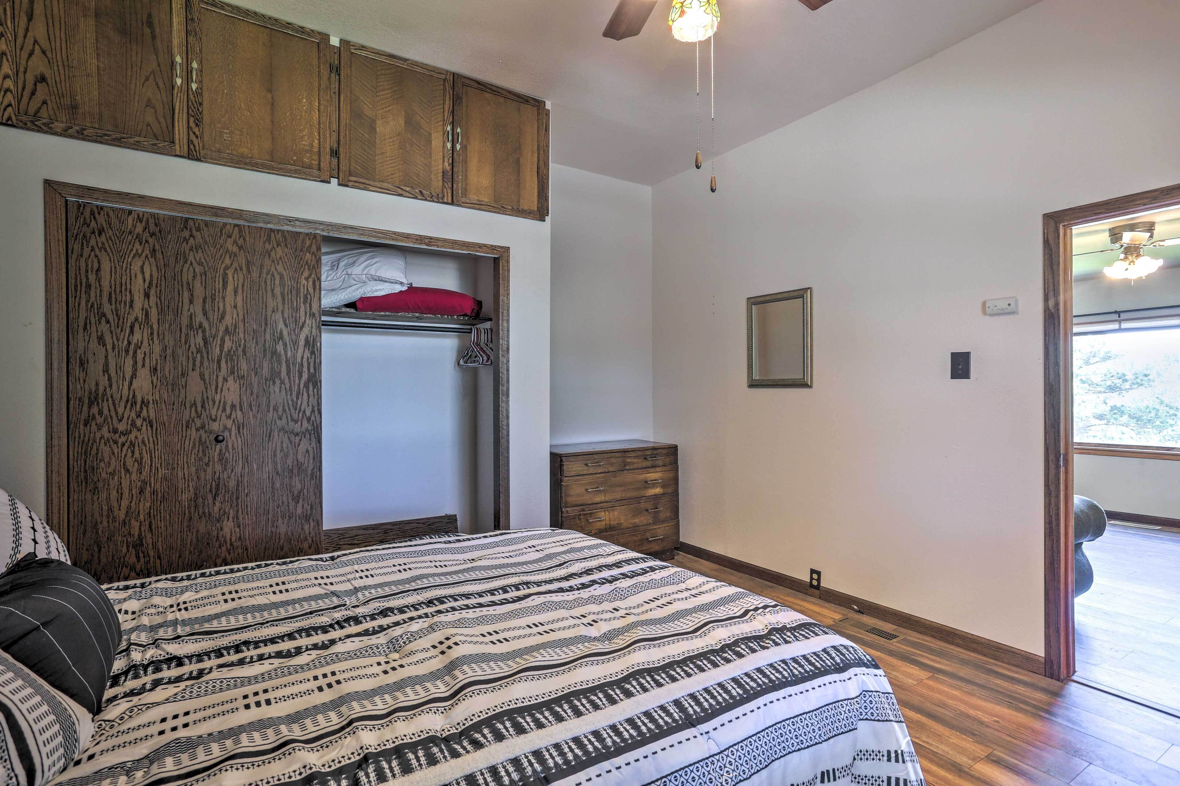Une chambre à coucher avec un grand lit, une armoire en bois et une petite commode.