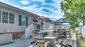 A patio area with outdoor furniture, including chairs and a table, and a barbecue grill. - Resort Home ~ 1 Mi to Myrtle Beach Access! (Murrells Inlet)
