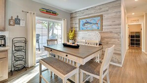 A dining area with a wooden table, white chairs, and a bench. There is a metal rack with baskets, a painting of a fish on the wall, and a sign that reads "Beach House". - Resort Home ~ 1 Mi to Myrtle Beach Access! (Murrells Inlet)