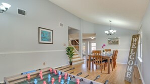 A room with a foosball table, a dining area with wooden chairs and a table, a staircase, and a 'WELCOME' sign. - Austin Vacation Rental w/ Yard ~ 14 Mi to Downtown (Austin)