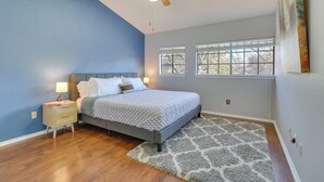 A bedroom with a bed, nightstands, a ceiling fan, and a window with blinds. - Austin Vacation Rental w/ Yard ~ 14 Mi to Downtown (Austin)