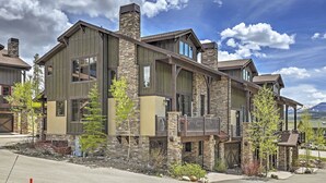 A modern two-story house with a stone facade, large windows, and a balcony. - Lavish Fraser Townhome With Deck & Mountain Views! (Winter Park)