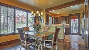 A spacious dining area with a wooden table, chairs, and a chandelier. - Lavish Fraser Townhome With Deck & Mountain Views! (Winter Park)