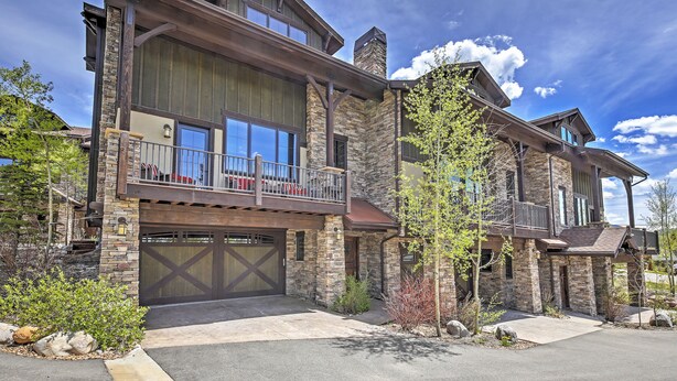 A two-story house with a stone facade, large windows, and a balcony. - Lavish Fraser Townhome With Deck & Mountain Views! (Winter Park)
