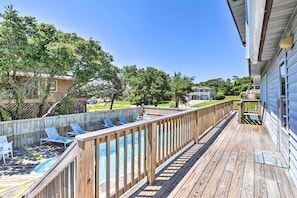 A wooden deck with lounge chairs and a pool.