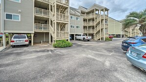 A multi-story residential building with balconies and a parking area. - Beachfront Condo w/ Unobstructed Ocean Views! (Oak Island)