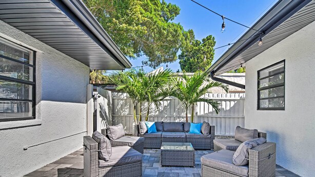 A patio area with wicker furniture, including a sofa and chairs, and a small table. - Pet-friendly Madeira Beach Studio Near Coast! (Madeira Beach)
