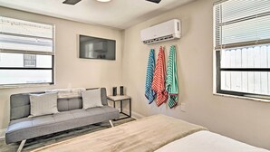 A bedroom with a bed, a sofa, a ceiling fan, an air conditioning unit, and a window with blinds. - Pet-friendly Madeira Beach Studio Near Coast! (Madeira Beach)