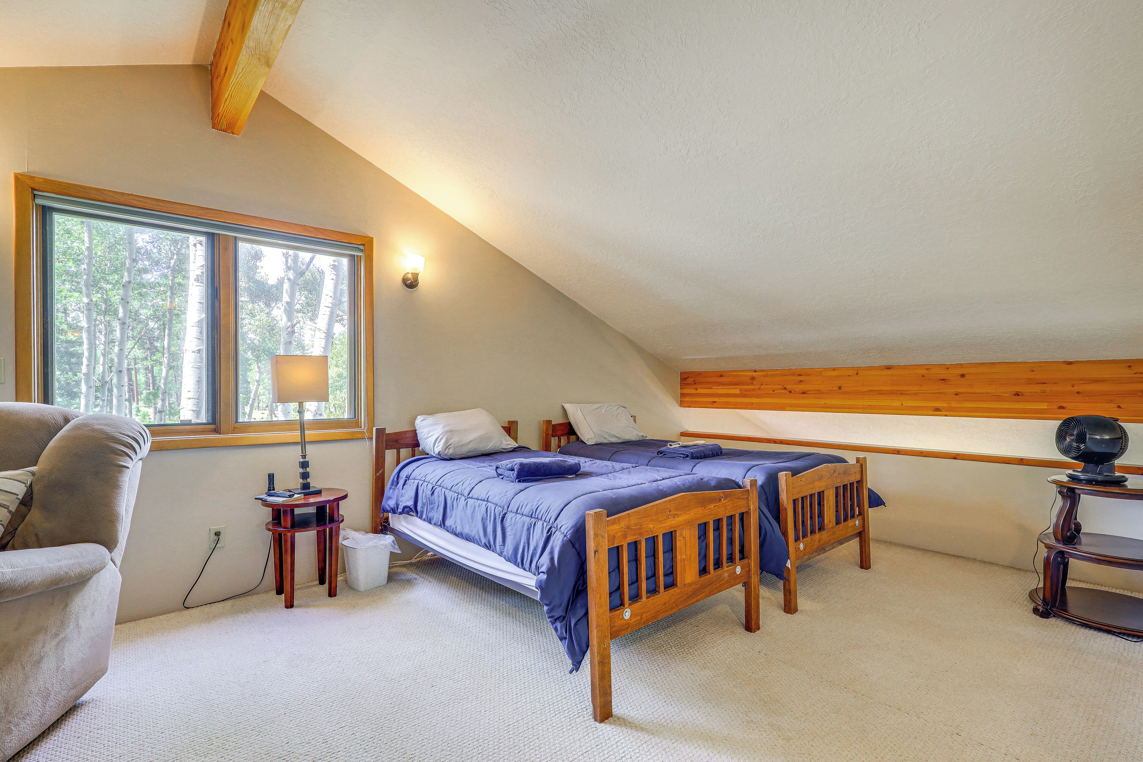 Een slaapkamer met een bed, een stoel, een lamp en een raam.