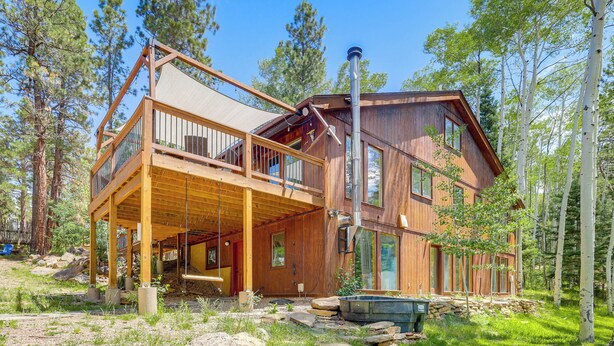 A wooden cabin with a balcony, a chimney, and a stone foundation. - Home w/ Hot Tub: 5 Mi to Angel Fire Bike Park (Angel Fire)