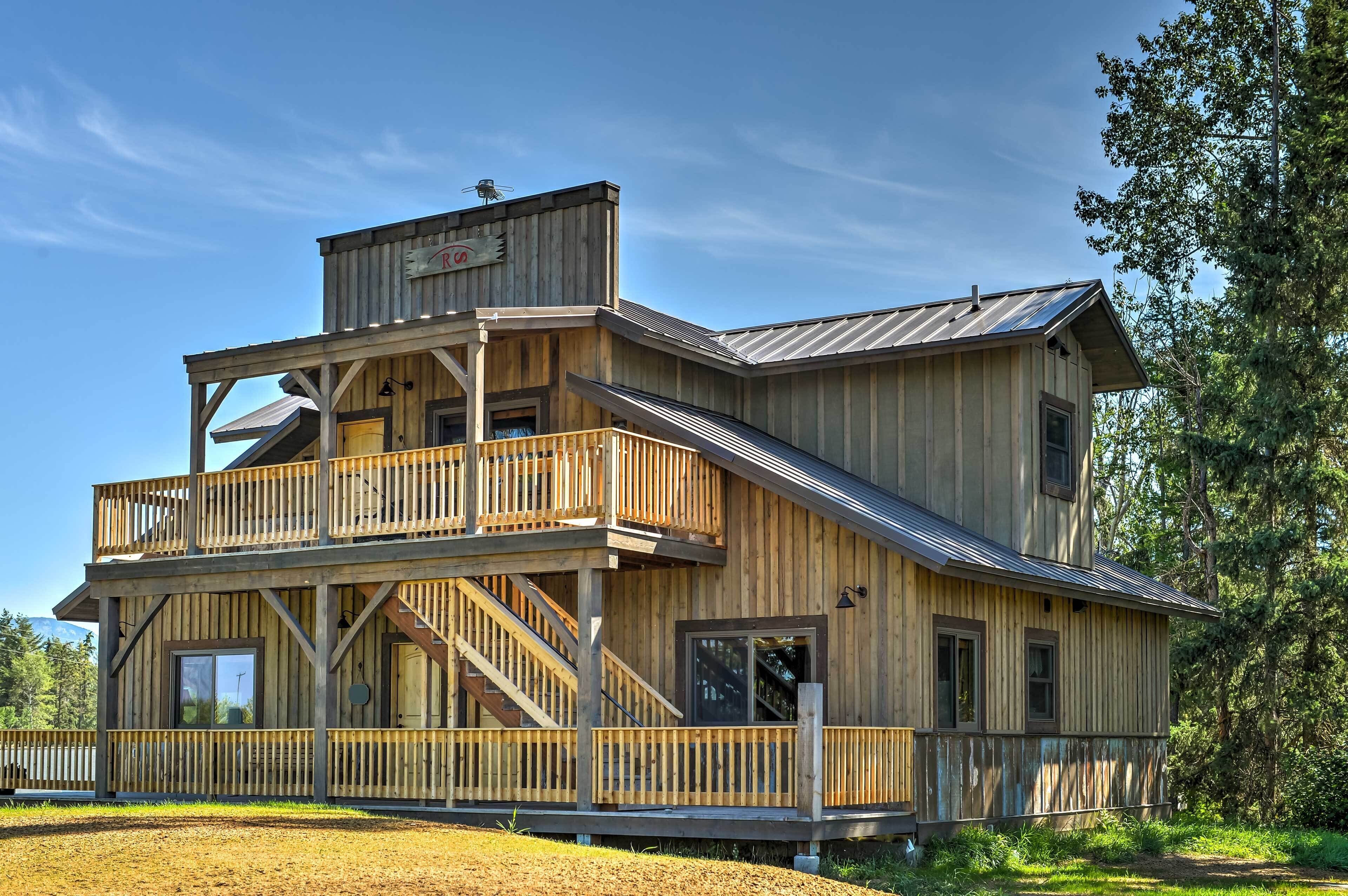 A two-story wooden building with a balcony, a staircase, and a metal roof.
