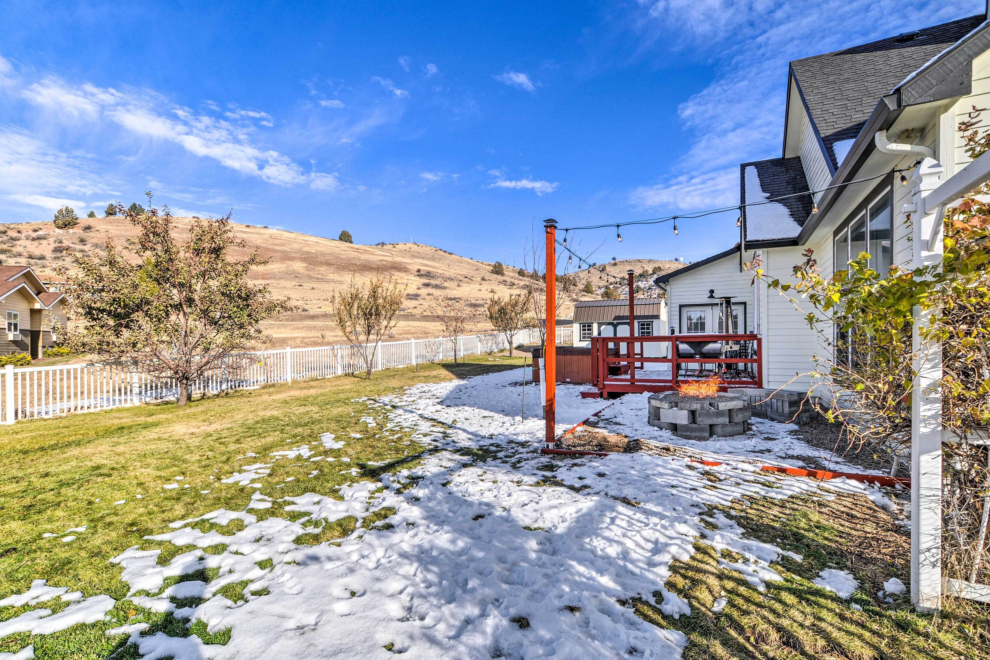 A residential area with a house, a red metal structure, and a white fence.
