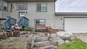 A two-story house with a front porch, a wooden bench, and a flag. - Flathead Lake-view Studio: 38 Mi to Blacktail (Big Arm)