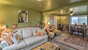 A cozy living room with a sofa, chairs, a coffee table, and a dining area with a table and chairs. - Flathead Lake-view Studio: 38 Mi to Blacktail (Big Arm)