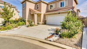 A two-story residential house with a garage, a driveway, and a landscaped front yard. - Fresno Home w/ Grill - 9 Mi to Downtown (Fresno)