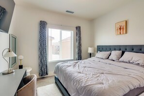 A bedroom with a large bed, a desk, and a chair. - Fresno Home w/ Grill - 9 Mi to Downtown (Fresno)