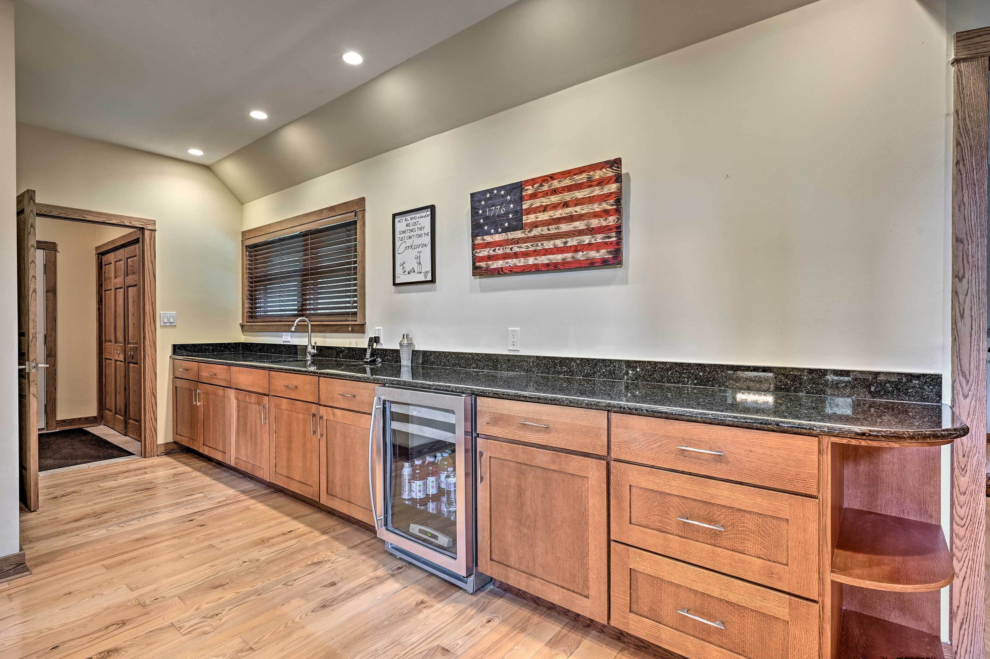 A kitchen with wooden cabinets, a stainless steel refrigerator, and a granite countertop.