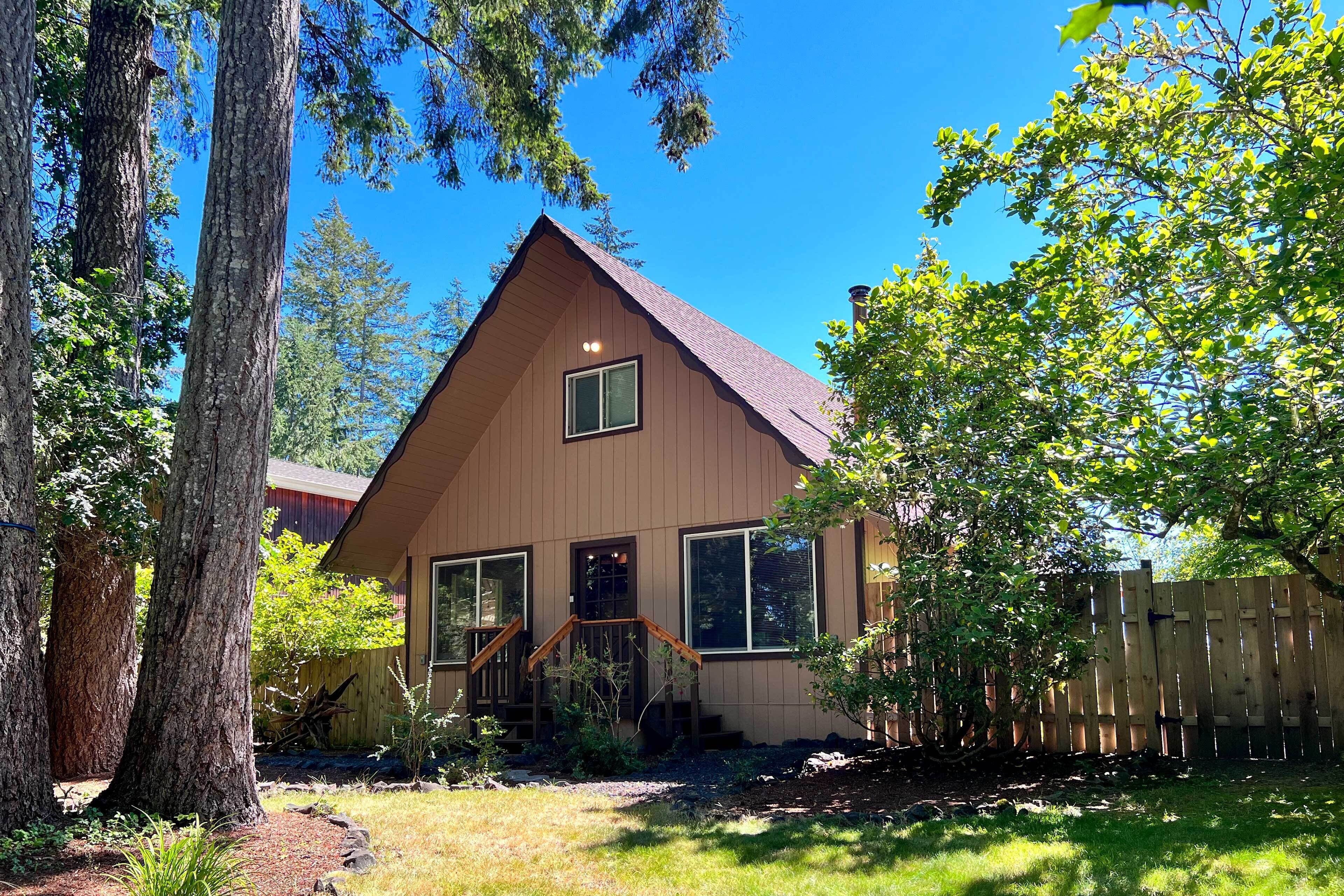 A two-story house with a sloped roof, large windows, and a wooden deck.