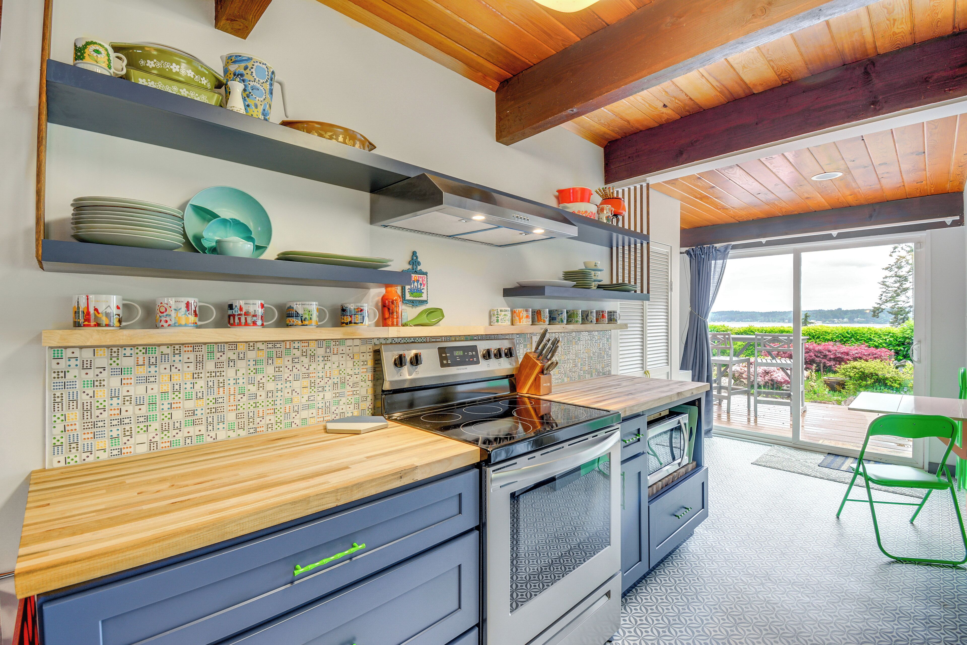 Een moderne keuken met een ingebouwde oven, een houten aanrecht en een spatwand met een tegelpatroon.