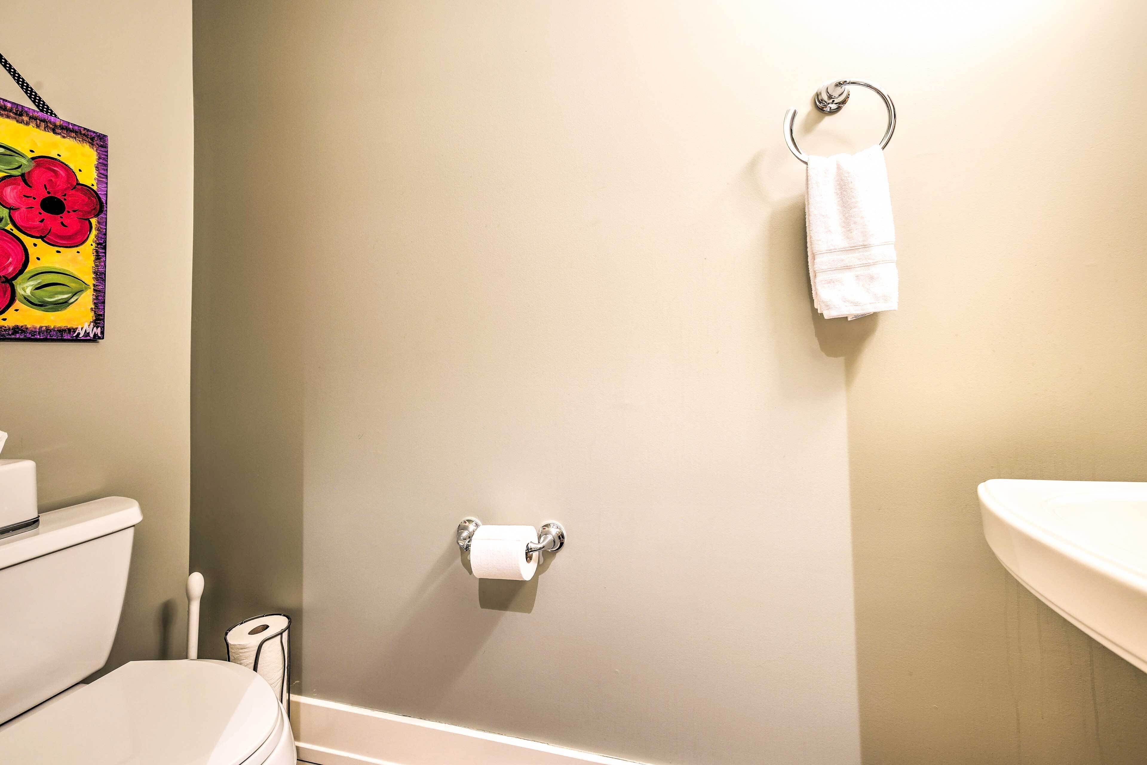 Une salle de bain équipée de toilettes, d’un porte-serviettes et d’un support à papier toilette.