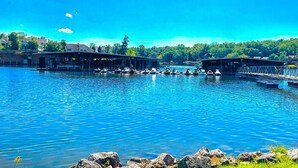 A marina with boats docked, covered structures, and a clear blue sky. - 1 Mi to Lake of the Ozarks: Condo w/ Pool Access (Lake Ozark)