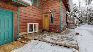 A wooden cabin with a green door, a yellow door, and a wooden staircase leading to a porch. - Ideally Located Fairbanks Vacation Rental! (Fairbanks)
