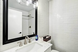 A bathroom with a white sink, two faucets, a large mirror, and a toilet. - Lovely Solana Beach Home w/ Views: 2 Mi to Ocean! (Solana Beach)