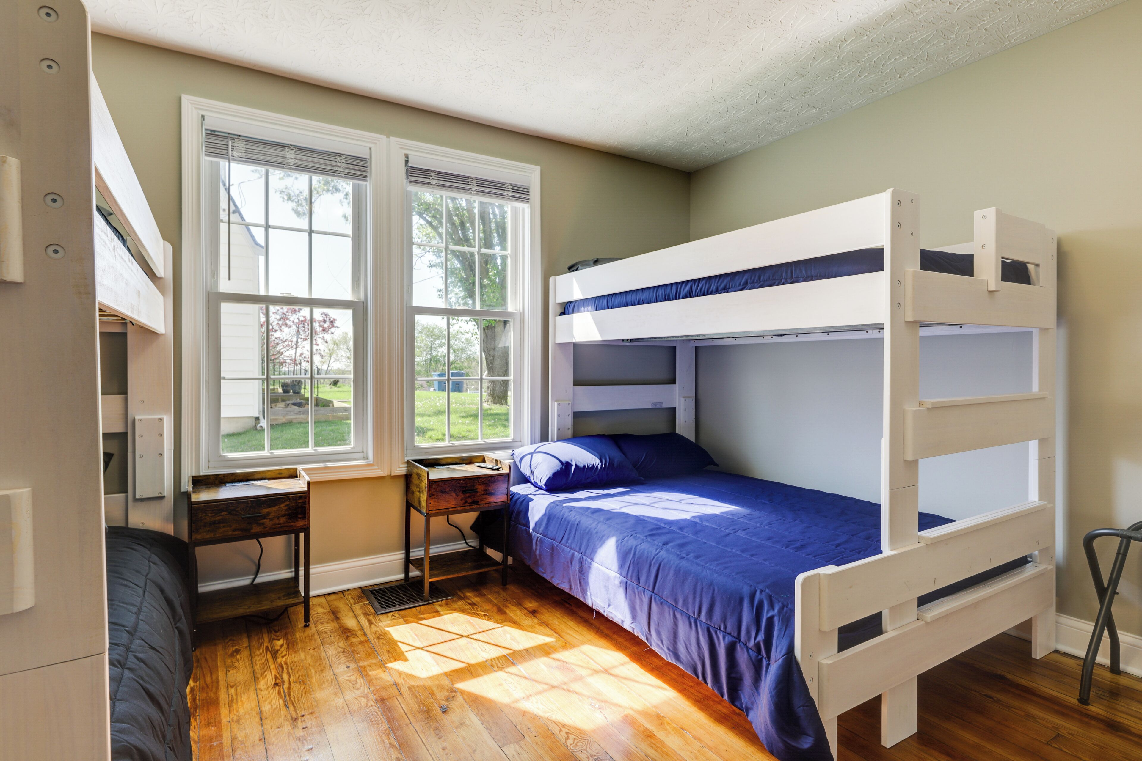 Une chambre avec un lit superposé, un bureau et une fenêtre.