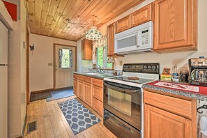 A kitchen with wooden cabinets, a stainless steel stove, and a microwave.