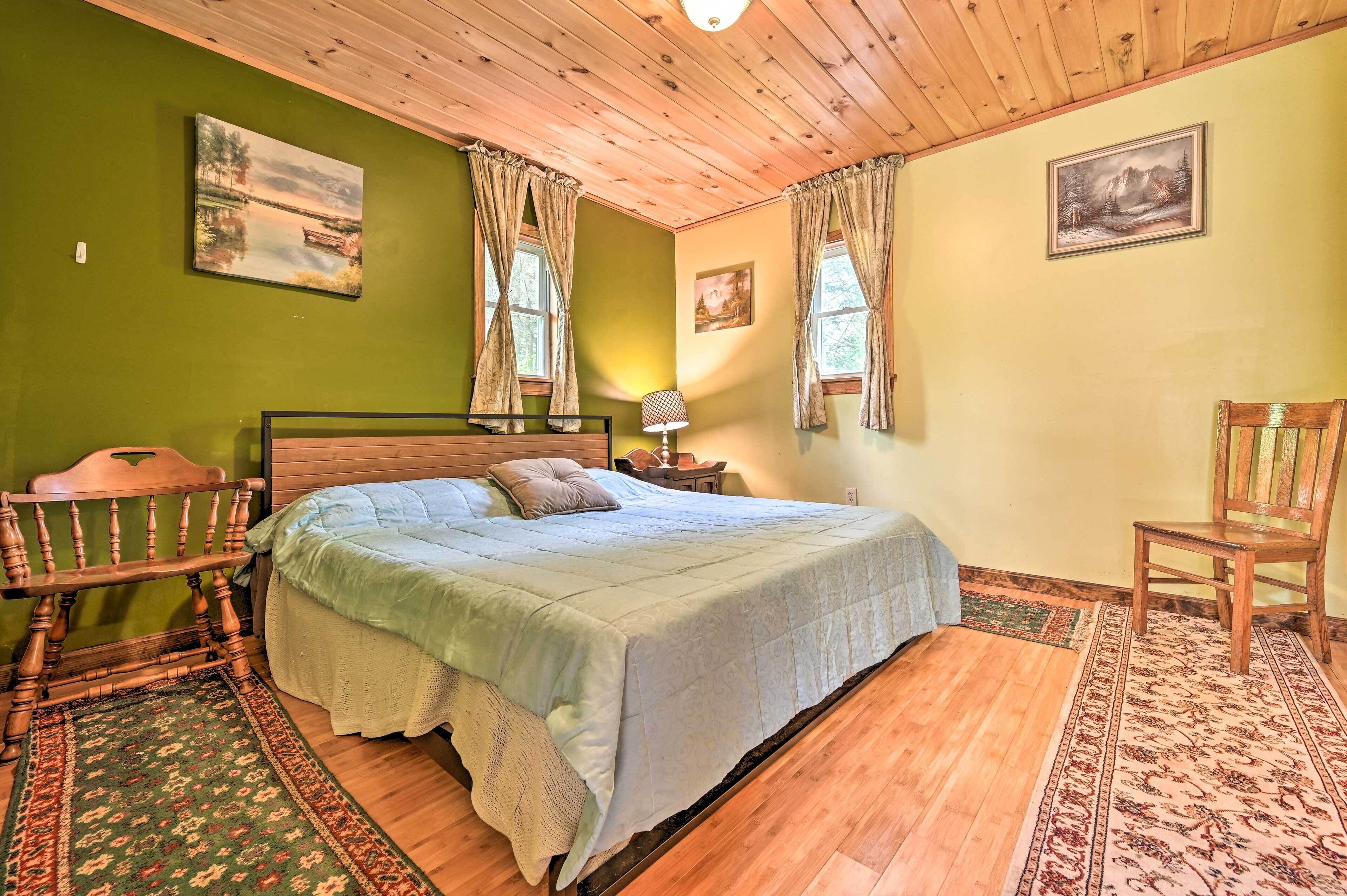 Una camera accogliente con un letto di legno, un comodino, una lampada e una sedia.
