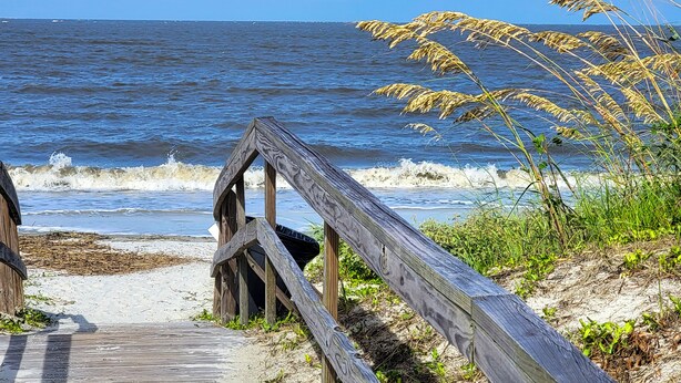 A wooden boardwalk leading to a beach with waves crashing onto the shore. - Harbor Island Condo w/ Pool Access: Walk to Beach! (Harbor Island)