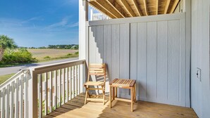A wooden deck with a white railing, a wooden chair, and a small table. - Harbor Island Condo w/ Pool Access: Walk to Beach! (Harbor Island)