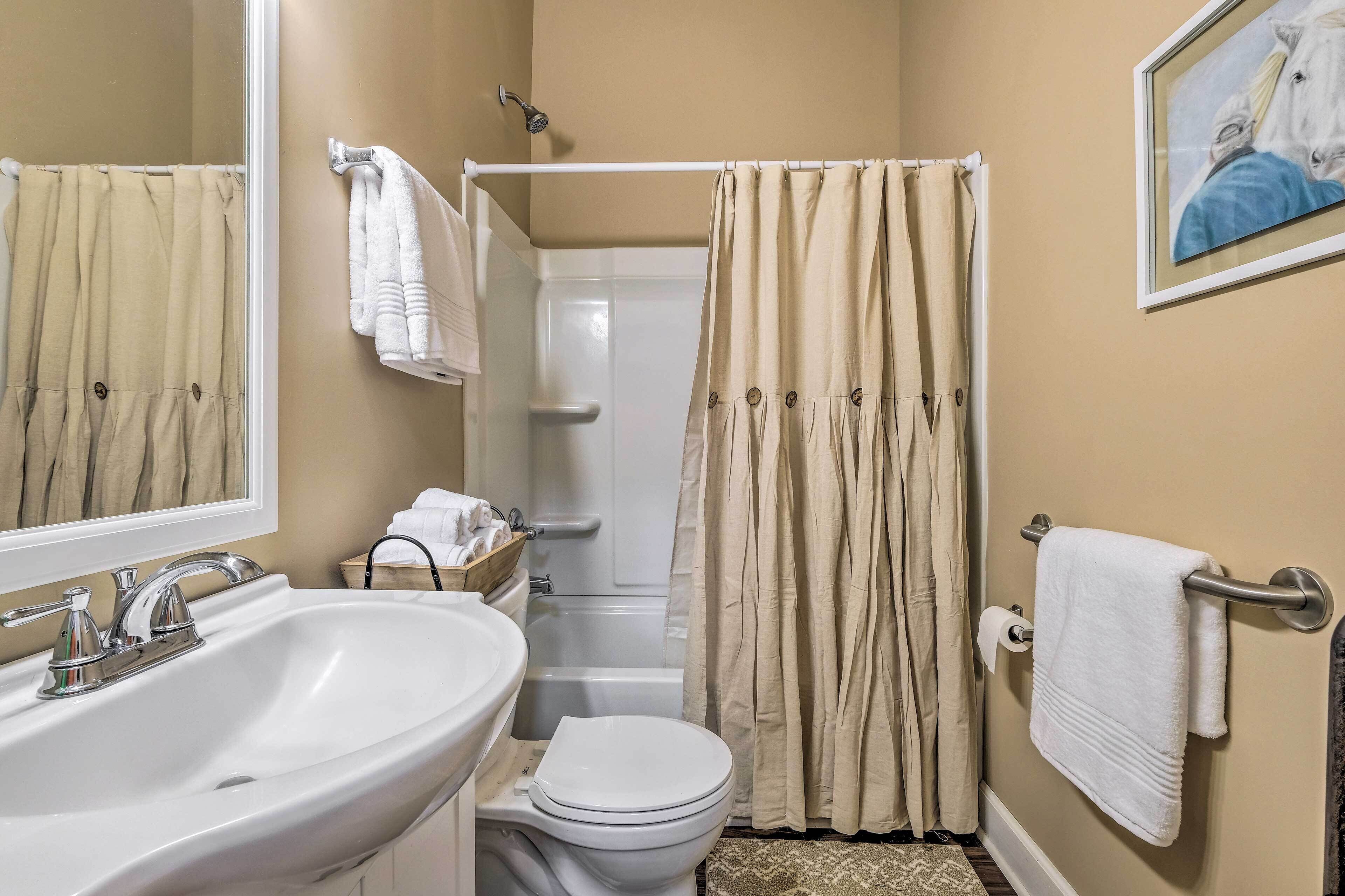 A bathroom with a sink, toilet, and shower curtain.