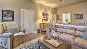 A living room with a sofa, armchair, coffee table, and a ceiling fan. - Quaint Apartment in Historic Georgetown! (Georgetown)