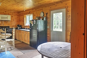 A wooden cabin kitchen with a refrigerator, microwave, and wooden cabinets. - Gould City Lakefront Hideaway w/ Dock & Rowboat! (Gould City)
