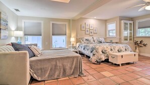 A bedroom with a bed, a sofa, a nightstand, a dresser, and a window with blinds. - Renovated Ozona Home w/ Views - Steps to Gulf (Palm Harbor)