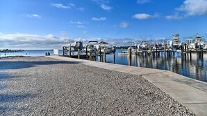 A marina with boats docked at piers, a pebbled beach, and a clear blue sky. - Renovated Ozona Home w/ Views - Steps to Gulf (Palm Harbor)