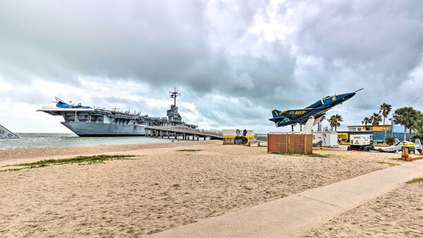 Un porte-avions était amarré sur une plage, et un avion de chasse était exposé à proximité.