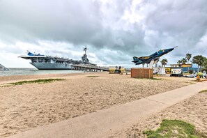 An aircraft carrier docked at a beach with a jet on display nearby. - Breezy Beachfront Condo in Heart of Corpus Christi (Corpus Christi)