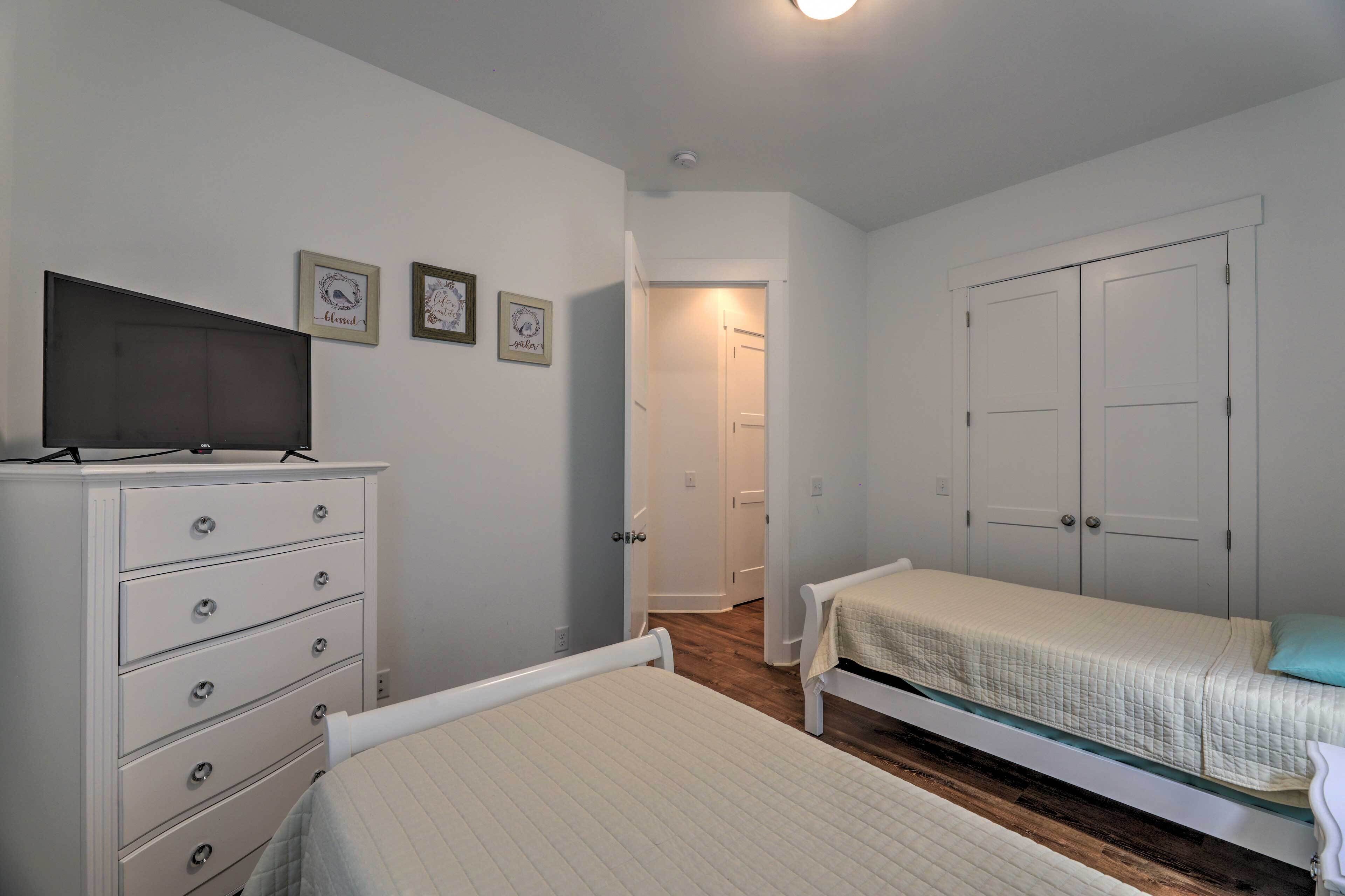 A bedroom with a bed, a dresser, a television, and a wardrobe.