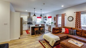 A modern kitchen with a central island, bar stools, and pendant lighting. - Convenient Fairbanks Guest Suite w/ Grill! (Fairbanks)