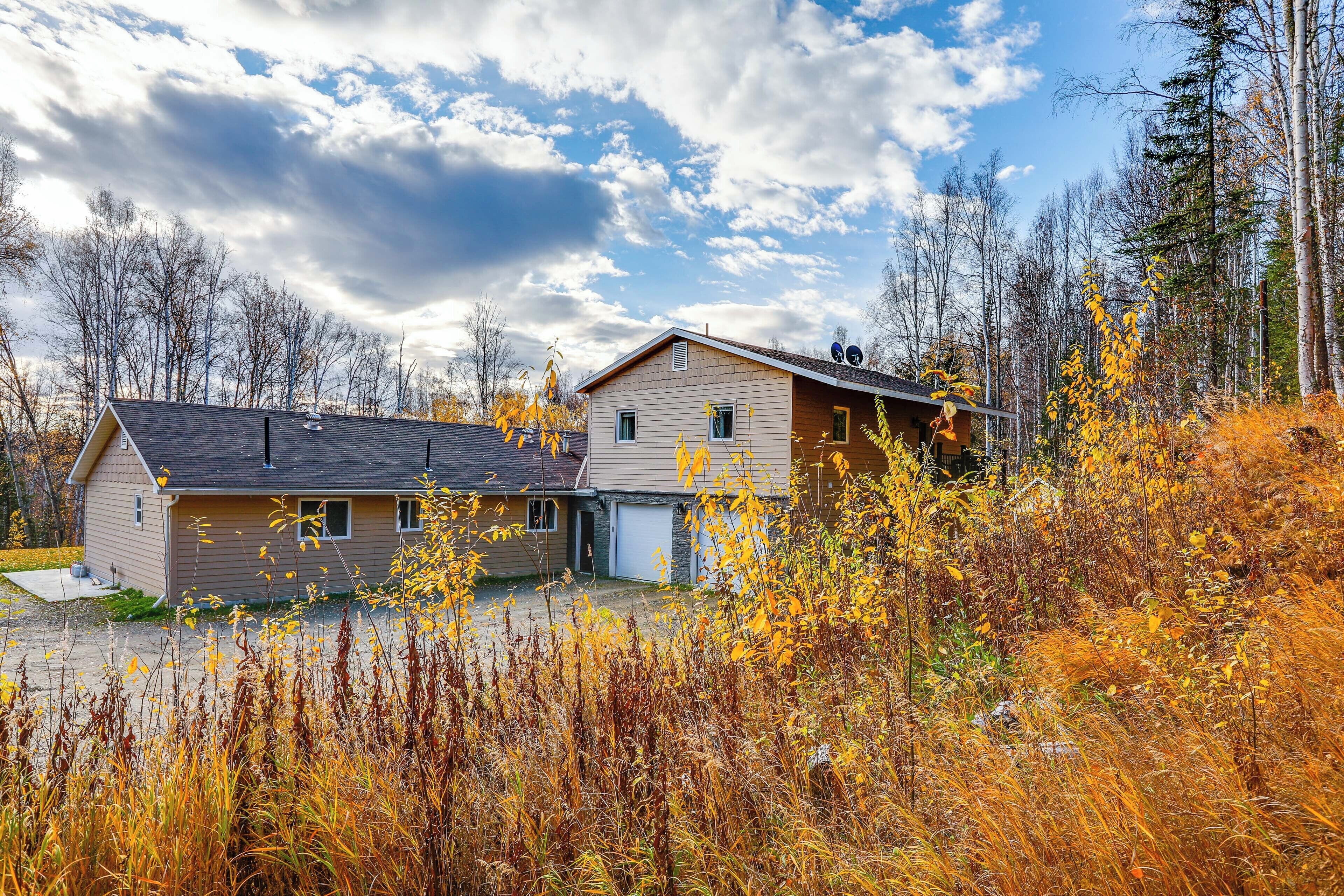Ein zweistöckiges Haus mit Garage, umgeben von Herbstlaub und Bäumen.