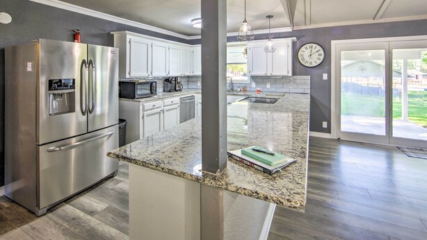 A modern kitchen with stainless steel appliances, granite countertops, and a large island. - Lakefront Family Home, Recently Renovated! (Trinidad)
